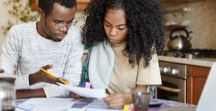 Jeune couple examinant les factures de prêt étudiant